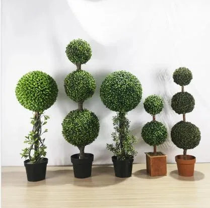 Pianta di bosso con palline verdi di erba artificiale per la decorazione del giardino domestico